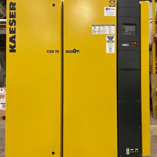 A large, yellow industrial machine labeled "KAESER CSD 75 SIGMA." The machine has a black control panel on the right side with various buttons and a digital display.