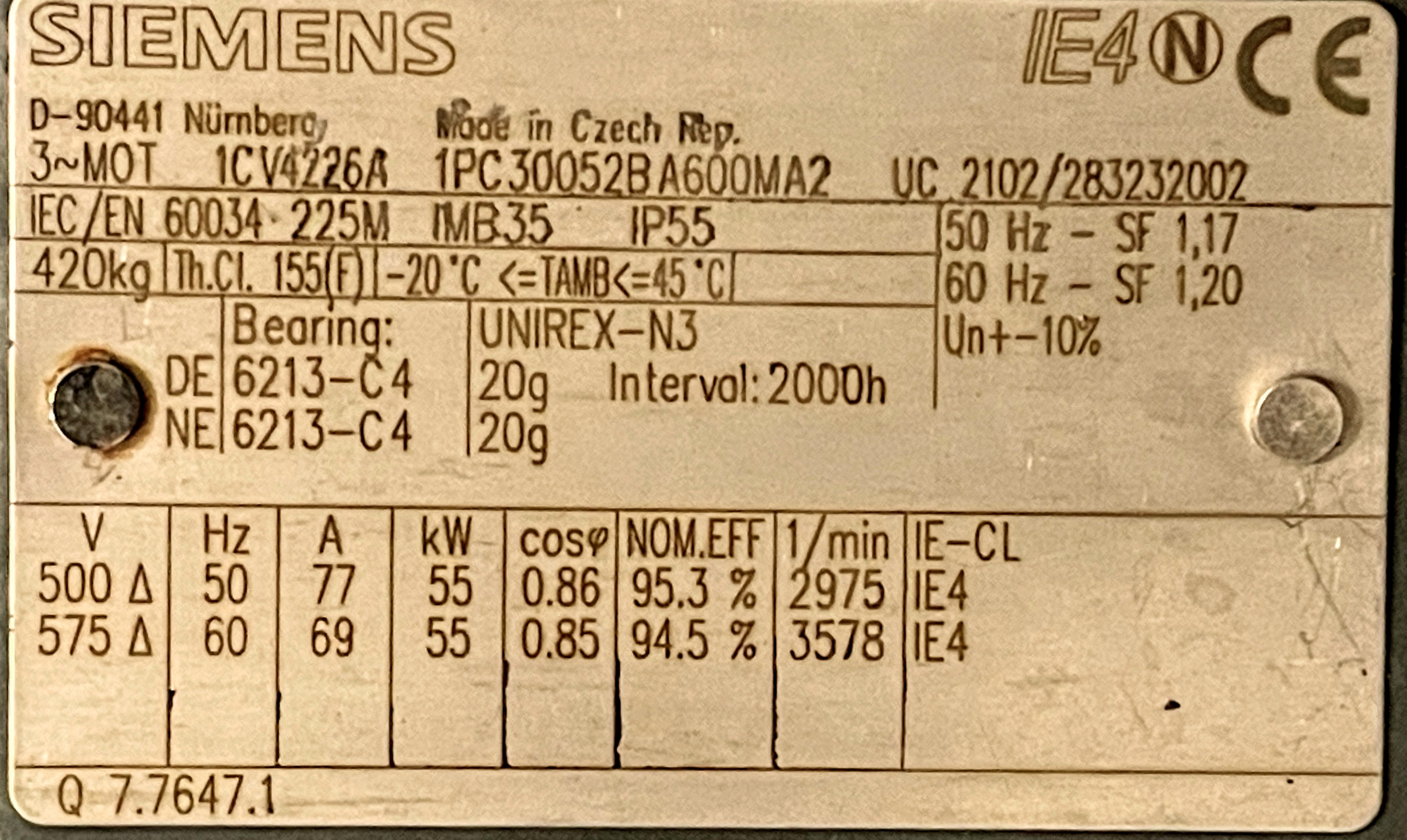 A metallic Siemens motor nameplate displaying technical specifications including model, power, voltage, RPM, and manufacturing details in multiple languages.